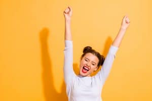 Portrait of her she nice-looking attractive lovely winsome sweet cheerful cheery optimistic girl having fun rejoicing raising hands up party isolated on bright vivid shine yellow background.