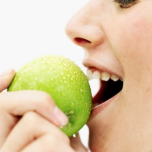 Young woman biting into an apple